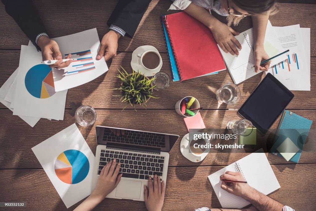 Boven weergave van onherkenbaar zakenmensen werken aan de tafel.