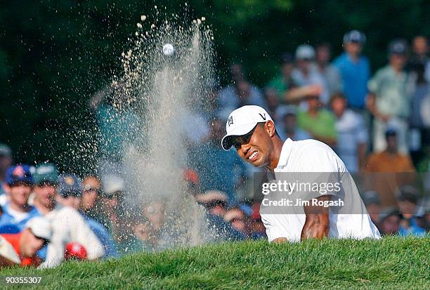 Tiger Woods works out of a bunker onto the 11th green during the second round of the Deutsche Bank Championship held at TPC Boston on September 5,...