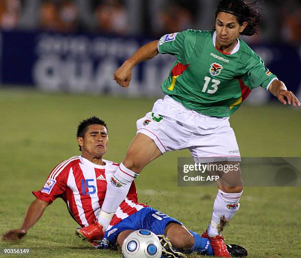 Paraguayan footballer Osvaldo Martinez marks Bolivian Marvin Vejarano, during a FIFA World Cup South Africa-2010 qualifier match in Asuncion, on...