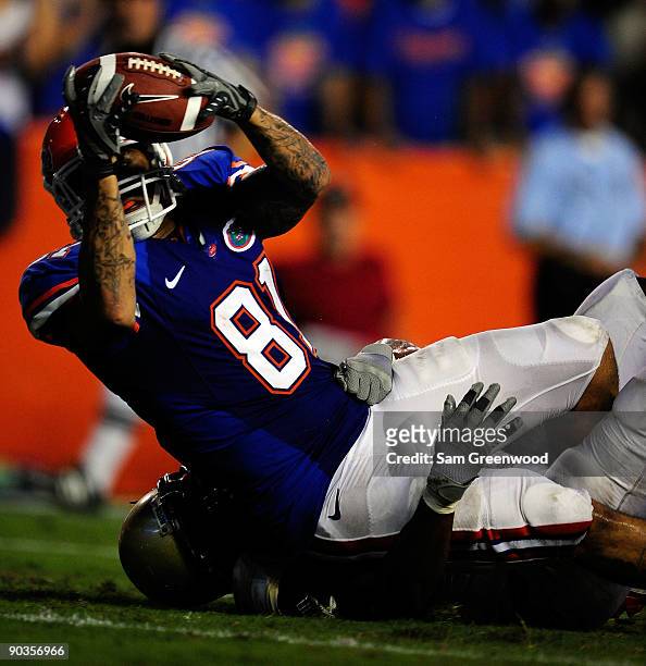 Aaron Hernandez of the Florida Gators is tackled as he makes a touchdown over Fred Godfrey of the Charleston Southern Buccaneers during the game at...