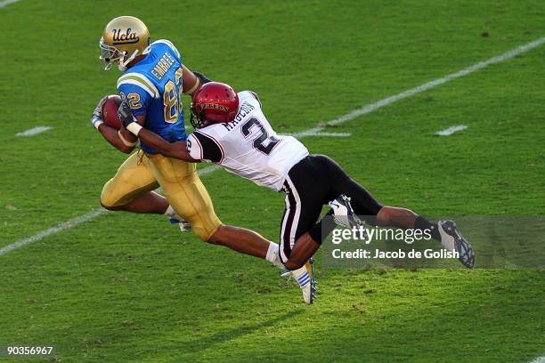 Taylor Embree of the UCLA Bruins runs the ball before getting tackeled by Davion Mauldin of San Diego State at Rose Bowl on September 5, 2009 in...