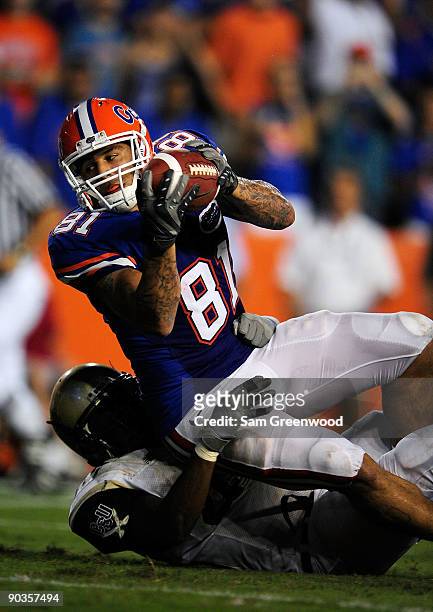 Aaron Hernandez of the Florida Gators runs for a touchdown over Fred Godfrey of the Charleston Southern Buccaneers during the game at Ben Hill...