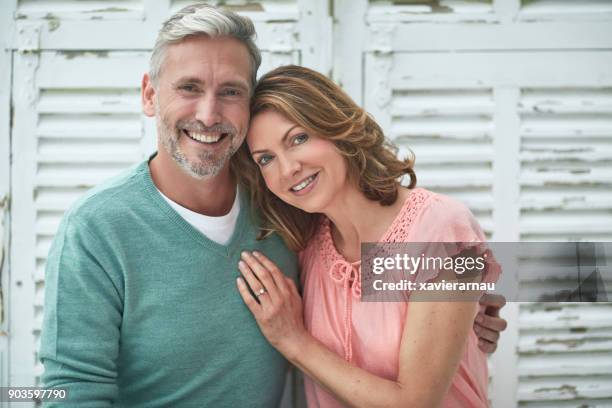 portrait of mature couple smiling outdoors - hands on chest stock pictures, royalty-free photos & images