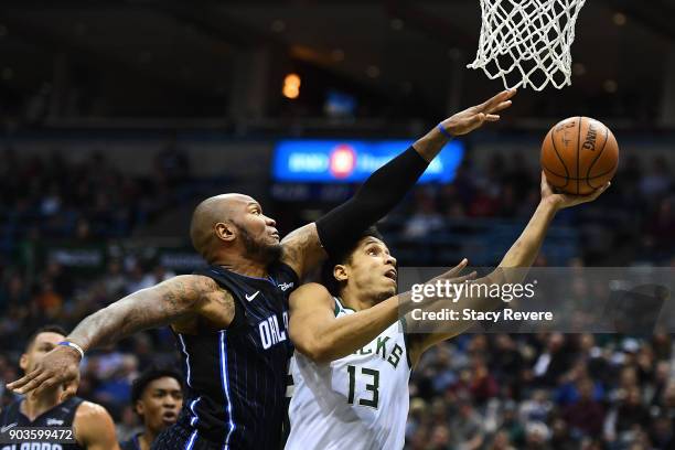 Marreese Speights of the Orlando Magic defends a shot by Malcolm Brogdon of the Milwaukee Bucks during the first half of a game at the Bradley Center...