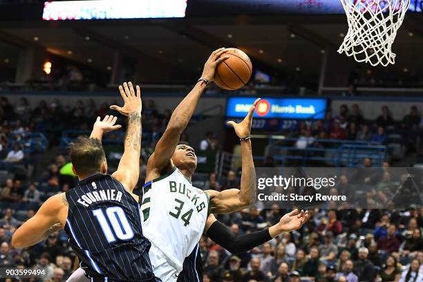 Giannis Antetokounmpo of the Milwaukee Bucks is fouled by Evan Fournier of the Orlando Magic during the first half of a game at the Bradley Center on...