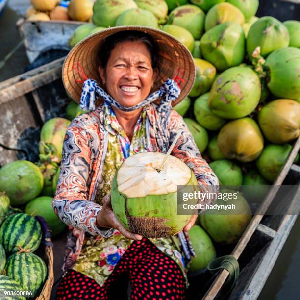 mujer vietnamita vendiendo cocos en flotante mercado, delta del río mekong, vietnam - mekong fotografías e imágenes de stock