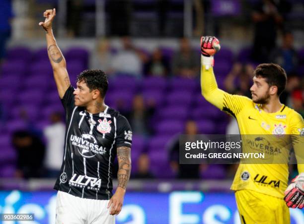 Giovanni Augusto and goalkeeper Caique França of Brazilian club Corinthians celebrate after their victory over Dutch club PSV Eindhoven in their...
