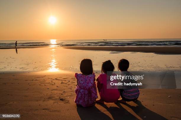 vietnamese little girls watching sunrise on the beach, vietnam - girl from behind stock pictures, royalty-free photos & images