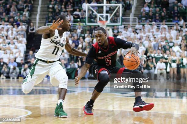 Mike Williams of the Rutgers Scarlet Knights handles the ball while defended by Lourawls Nairn Jr. #11 of the Michigan State Spartansat Breslin...