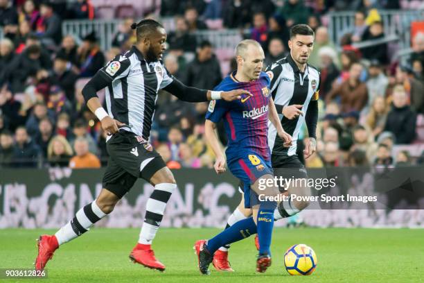 Andres Iniesta Lujan of FC Barcelona fights for the ball with Cheik Doukoure and David Remeseiro Salgueiro, Jason, of Levante UD during the La Liga...