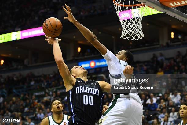 John Henson of the Milwaukee Bucks blocks a shot by Aaron Gordon of the Orlando Magic during the second half of a game at the Bradley Center on...