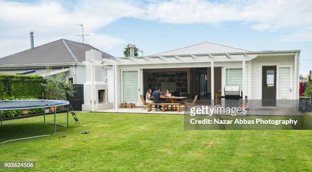 family having lunch at home. - beautiful house exterior stockfoto's en -beelden