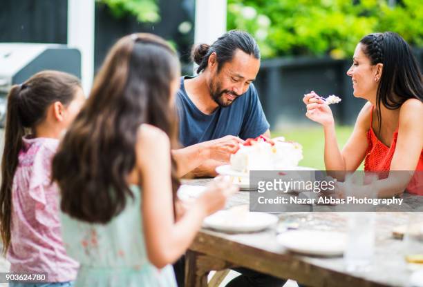 birthday cake cutting in a small mixed race family. - auckland food stock pictures, royalty-free photos & images