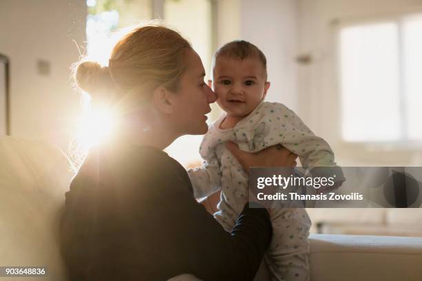 mother with her newborn son - smiling controluce foto e immagini stock