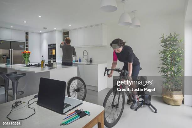 teenage girl training on bike indoors - flatten the curve fotografías e imágenes de stock