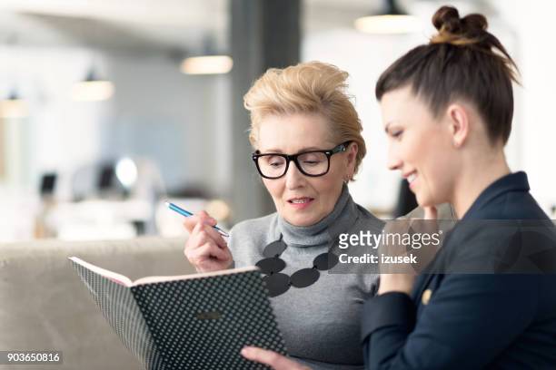 senior adviser talking with young businesswoman - role model stock pictures, royalty-free photos & images