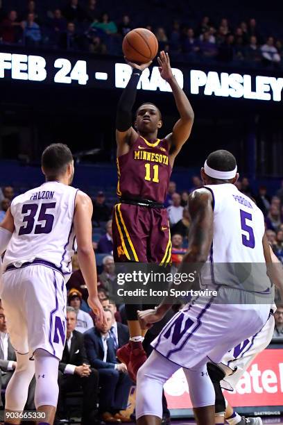 Minnesota Golden Gophers guard Isaiah Washington shoots the ball between Northwestern Wildcats forward Aaron Falzon and Northwestern Wildcats center...