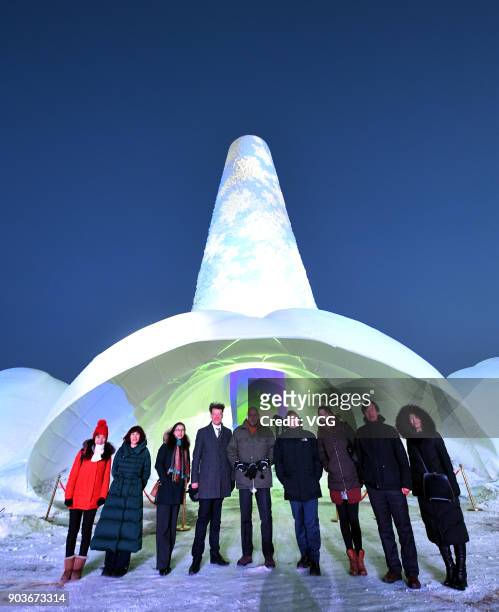 Visitors pose with a 30.5-metre-tall ice tower named "Flamenco Tower" during 2017 Harbin International Ice and Snow Construction Festival at Maple...