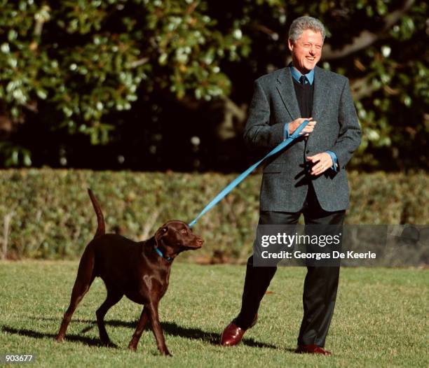 President Bill Clinton walks from the White House with wife Hillary and his dog Buddy December 30, 1998. The Clinton's will ring in the New Year with...