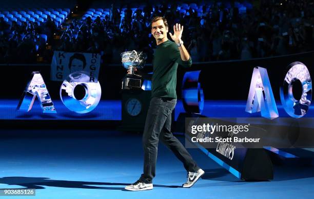 Roger Federer of Switzerland arrives on court with the Norman Brookes trophy during the 2018 Australian Open Official Draw at Melbourne Park on...