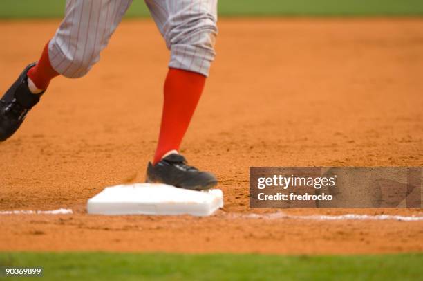 baseball player running to first baseball during baseball game - baserunner stock pictures, royalty-free photos & images