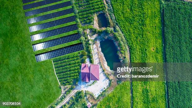 aerial view of solar energy farm with house and organic farm - climate research stock pictures, royalty-free photos & images