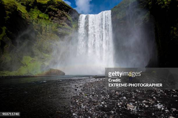 woman in front of waterfall - skogafoss waterfall stock pictures, royalty-free photos & images