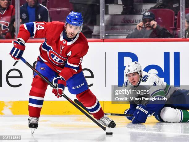 Tomas Plekanec of the Montreal Canadiens skates the puck past Derrick Pouliot of the Vancouver Canucks during the NHL game at the Bell Centre on...