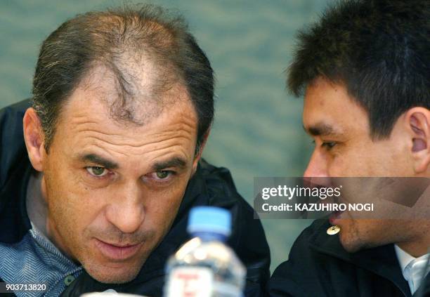 Paraguay's soccer club team Olimpia head coach Nery Alberto Pumpido chats with team captain Julio Cesar Enciso during a news conference in Yokohama,...