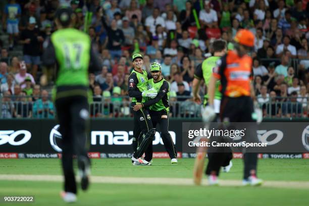 Farad Ahmed of the Thunder celebrates catching Will Bosisto of the Scorchers with team mate Jay Lenton off a delivery by team mate Mitch McClenaghan...