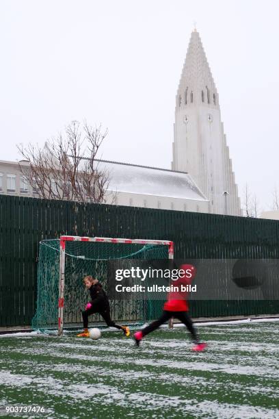 Fussball spielende Kinder am ersten Weihnachtsfeiertag unterhalb der Hallgrimskirkja in Reykjavik