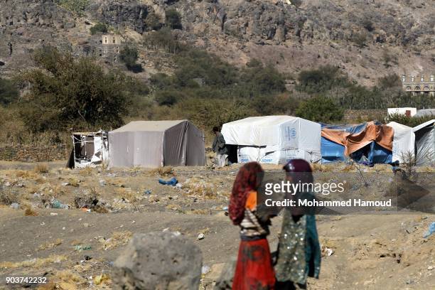 Displaced girls stand outside their family’s makeshift shelter at a displaced persons camp in Amran province northern Sana’a on January 10, 2018...