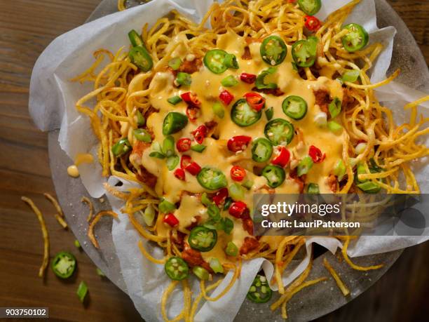 nacho style thin and crispy spiral fries with chili and cheese sauce - cheese sauce stock pictures, royalty-free photos & images