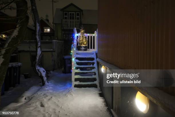 Þorláksmessa in Reykjavik -Beleuchteter Weihnachtsbaum vor einem Wohnhaus