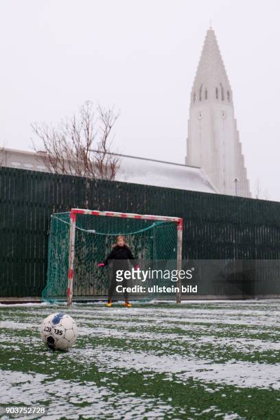 Fussball spielende Kinder am ersten Weihnachtsfeiertag unterhalb der Hallgrimskirkja in Reykjavik