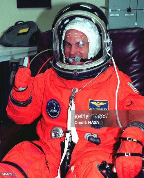 Pilot Frederick W. "Rick" Sturckow gives a "thumbs up" after donning his orange launch and entry suit in the Operations and Checkout Building. STS-88...