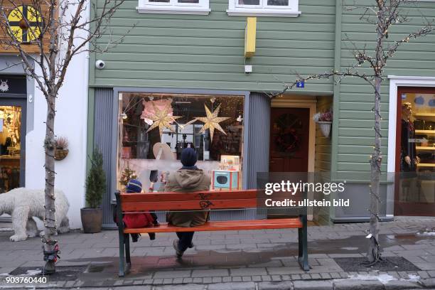 Vater und Sohn auf einer Bank in der Innenstaft von Reykjavik