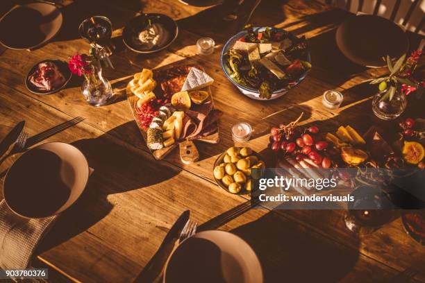 traditional cheese and fruit platter with mediterranean salad and dips - rustic dinner party stock pictures, royalty-free photos & images