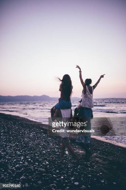 アイランドのビーチにピギーバックの乗車を与える若い多民族観光地 - 肩車 ストックフォトと画像
