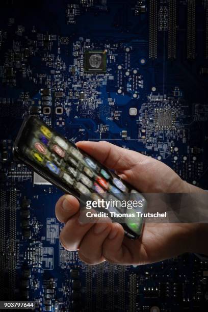 Berlin, Germany Symbolic photo on the topic of Data security on the smartphone. A smartphone is held in front of a computer board on January 11, 2018...