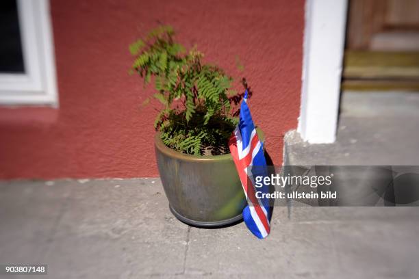 Isländische Flagge in einem Blumentopf vor einer Haustür in Reykjavik