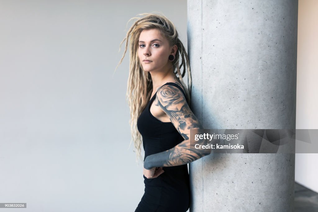 Retrato de mulheres jovens tatuados e piercings com dreadlocks loiros