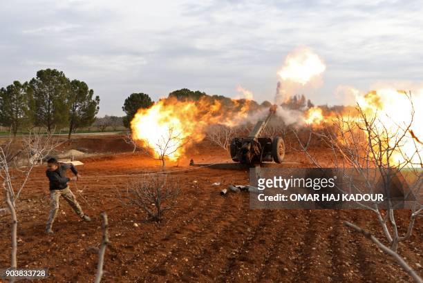 An opposition fighter fires a gun from a village near al-Tamanah during ongoing battles with government forces in Syria's Idlib province on January...