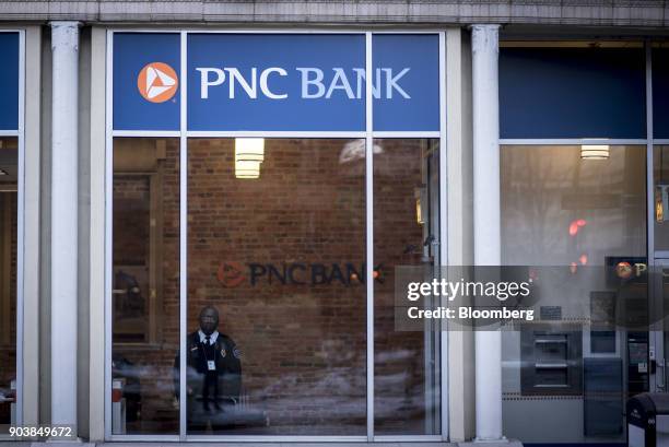 Security guard looks out the window of a PNC Financial Services Group Inc. Bank branch in downtown Chicago, Illinois, U.S., on Monday, Jan. 8, 2018....
