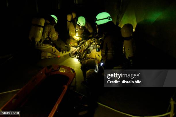 Fluoreszierende Feuerwehrhelme leuchten bei einer Übung der Atemschutznotfall trainierten Staffel der Feuerwache 1300 in den dunklen...