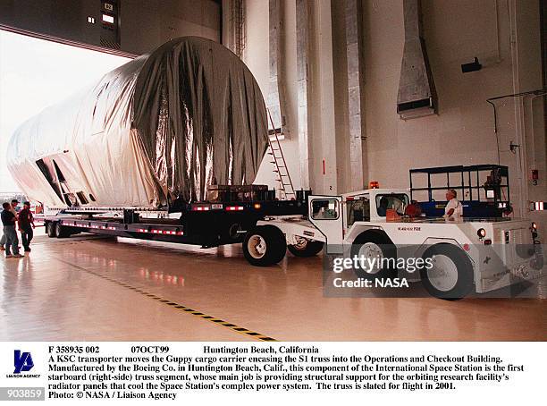 Huntington Beach, California A KSC transporter moves the Guppy cargo carrier encasing the S1 truss into the Operations and Checkout Building....