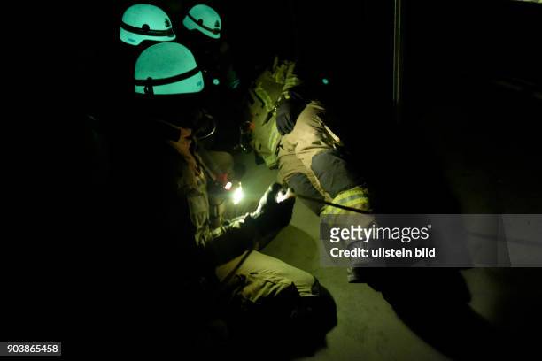 Fluoreszierende Feuerwehrhelme leuchten bei einer Übung der Atemschutznotfall trainierten Staffel der Feuerwache 1300 in den dunklen...
