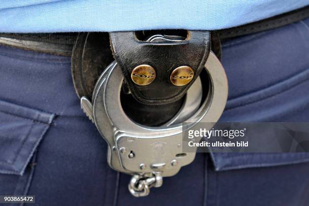 Handschlellen am Gürtel eines Polizisten