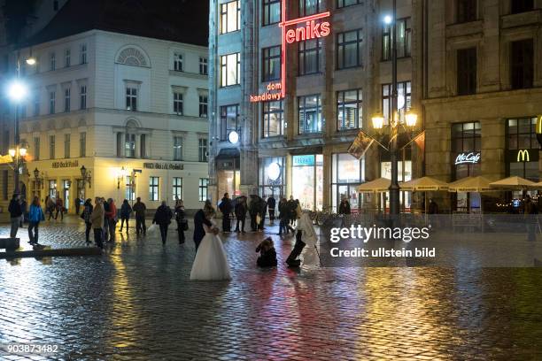 Brautpaar läßt sich nachts auf dem Rynek in der Altstadt von Wroclaw/Breslau fotografieren