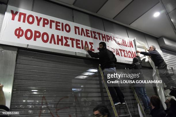 Communist-affiliated All-Workers Militant Front unionists set up a banner reading "Ministry of foreclosures and tax thieves" at the Greek Finance...